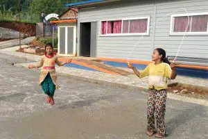 Jeunes filles de l'ethnie Chepang qui jouent devant leur nouveau foyer