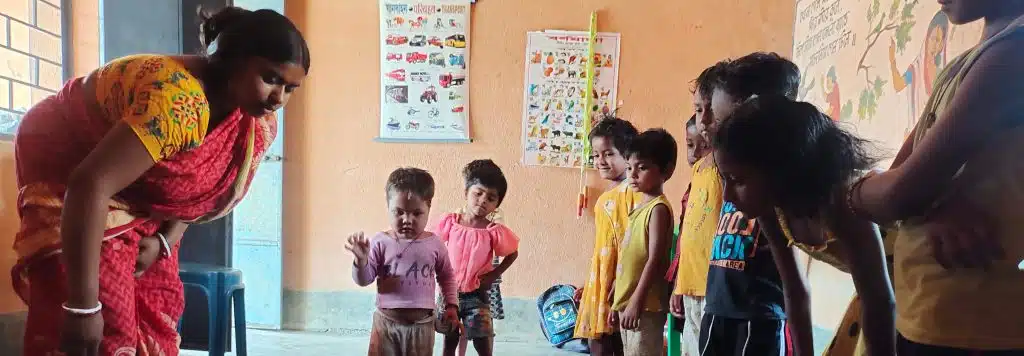 A teacher with young children at an Anganwadi center in India