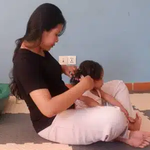 A nursery assistant does a little girl's hair in Cambodia