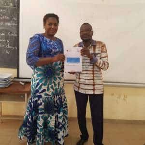 Deux éducateurs montrent le cahier de suivi pégagogique individuel des élèves de maternelle au Burkina Faso