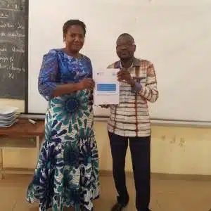 Two educators show the individual learning logbook for kindergarten pupils in Burkina Faso