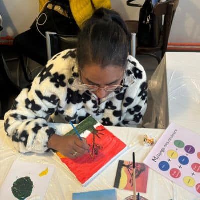 A woman paints during the women's café