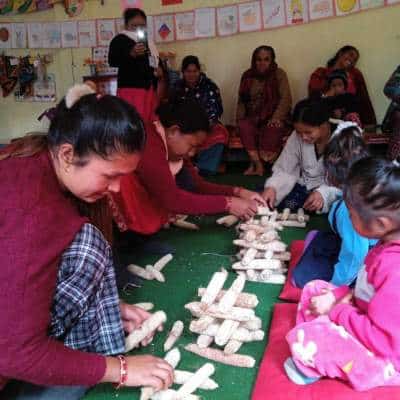 Une mère joue avec sa fille en atelier parents-enfants au Népal