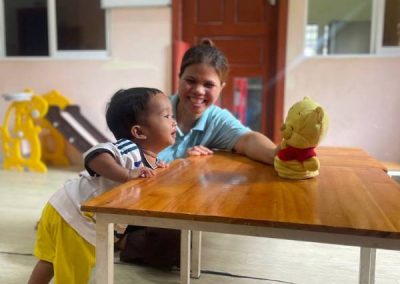 Bébé qui joue avec une auxiliaire Petite Enfance