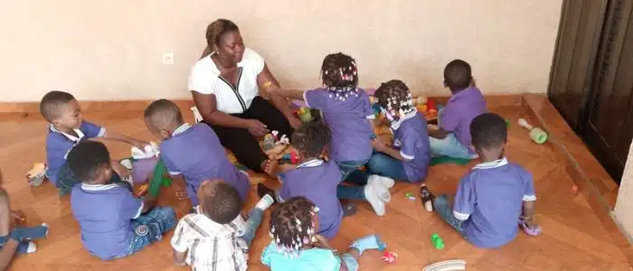 A child care provider and a group of children in Togo